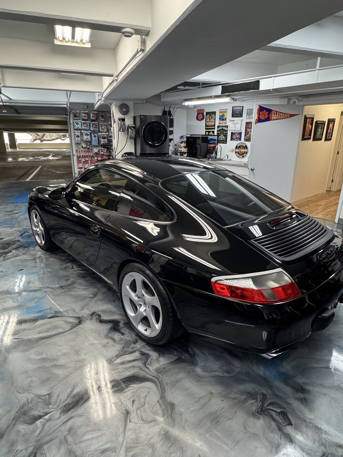 2002 Porsche 911 Carrera after paint correction and Borograph 2.0 — deep black gloss, rear three-quarter view